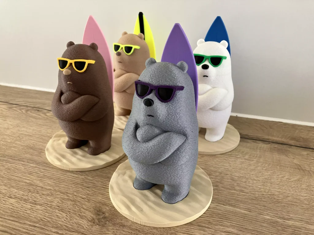 Quatre figurines d'ours surfeurs multicolores imprimées en 3D